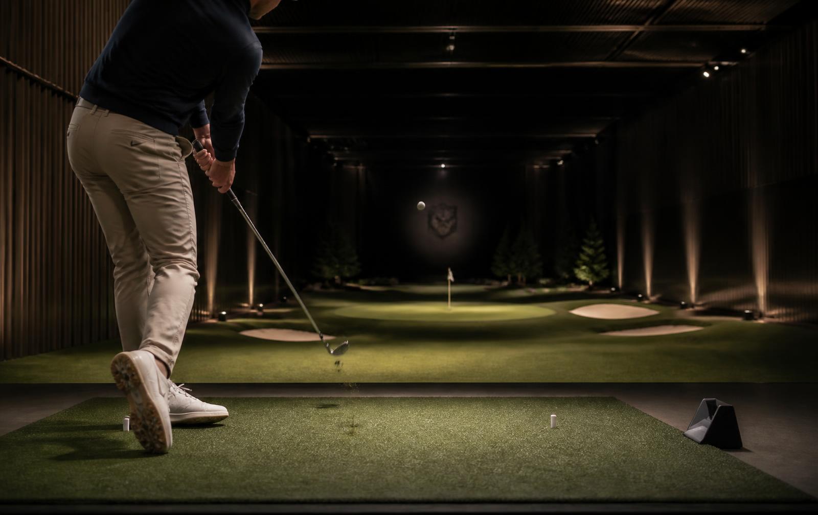 Golfare som slår en wedge mot en målgreen på cirka 40 meter i The Progress indoor range